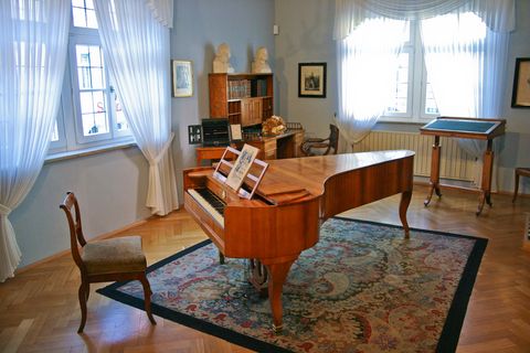Zimmer mit einem Klavier und antiken Möbelstücken