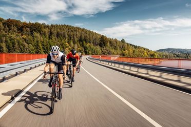 Radfahrer auf Stoneman Miriquidi Road. Im Hintergrund ist Natur mit Wald zu sehen.
