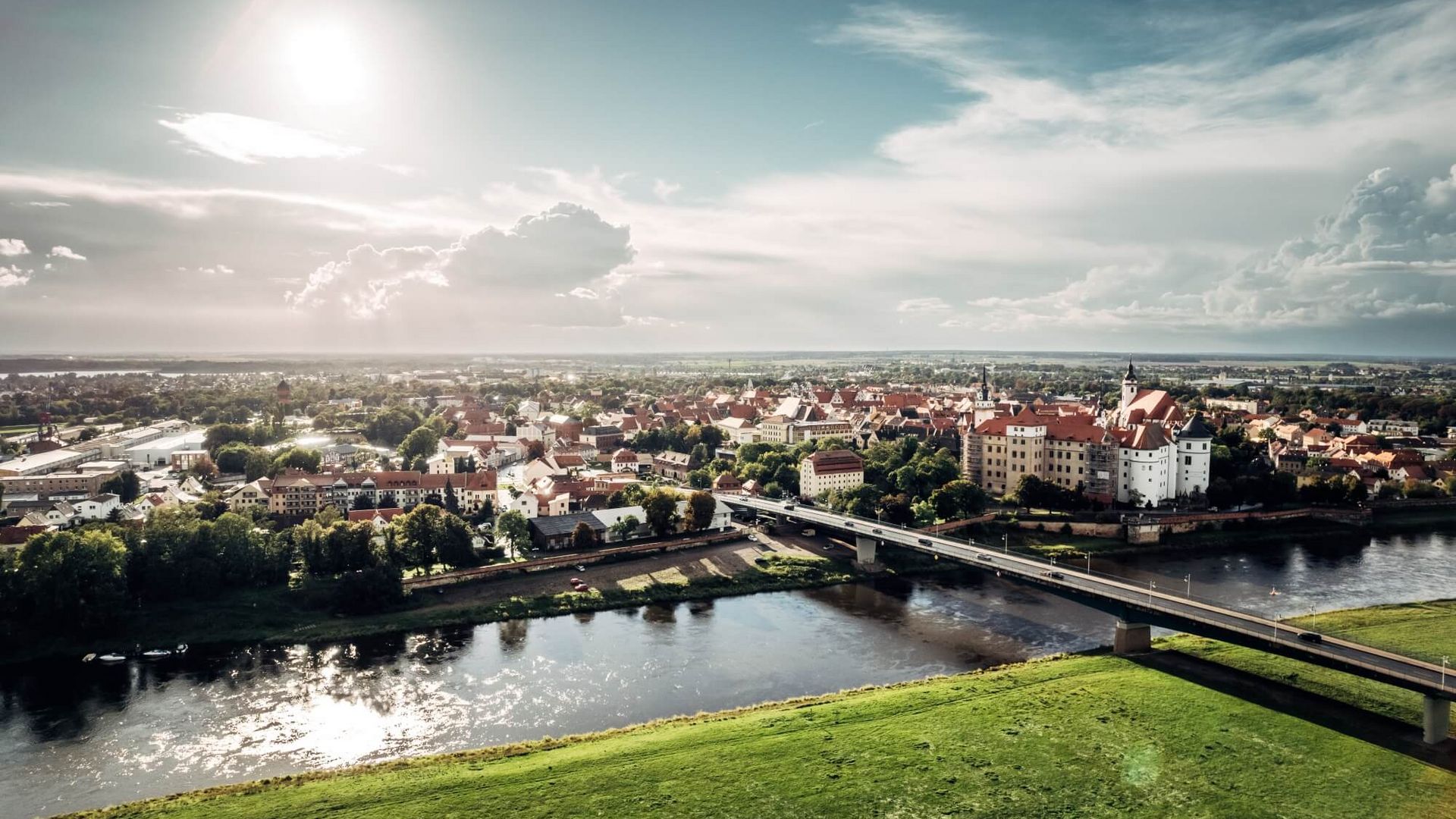 Sommerliche Stadtansicht auf Torgau mit Schloss Hartenfels und Elbe / City view of Torgau with Hartenfels Castle and River Elbe in summer